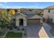 Beautiful home featuring a paver driveway, well-manicured lawn, desert landscaping, and mountains in the background at 20765 E Raven Dr, Queen Creek, AZ 85142