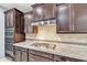 Well-appointed kitchen features stainless steel cooktop, oven and hood, plus granite countertops at 20765 E Raven Dr, Queen Creek, AZ 85142