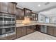 Modern kitchen features stainless steel appliances, dark wood cabinets, and granite countertops at 20765 E Raven Dr, Queen Creek, AZ 85142