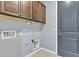 Functional laundry room with overhead cabinetry and essential utility connections, blending practicality with home aesthetics at 20765 E Raven Dr, Queen Creek, AZ 85142
