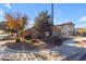 Inviting home on a corner lot with mature landscaping, well-maintained lawn, and a glimpse of the neighborhood at 20765 E Raven Dr, Queen Creek, AZ 85142