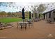 An outdoor patio with tables, chairs, and strung patio lights surrounded by desert landscape at 20801 N 90Th Pl # 271, Scottsdale, AZ 85255