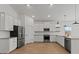 Modern kitchen features white cabinets, stainless steel appliances, and wood-look flooring at 23417 W Burton Ave, Buckeye, AZ 85326