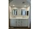 Bathroom boasts double sinks with framed mirrors, decorative mosaic backsplash, and warm lighting at 2426 E Turquoise Dr, Phoenix, AZ 85028