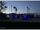 House exterior at night with blue uplighting, palm trees, and desert landscaping at 2426 E Turquoise Dr, Phoenix, AZ 85028