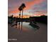 Outdoor pool area with sunset view, tall palm trees, and reflection in the water at 2426 E Turquoise Dr, Phoenix, AZ 85028