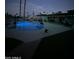 Backyard pool and patio lit up at dusk with green string lights, lounge furniture, and a dog at 2426 E Turquoise Dr, Phoenix, AZ 85028