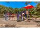 Community playground with slides and climbing equipment under a red shade structure at 2660 S Equestrian Dr # 103, Gilbert, AZ 85295