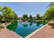 Community pond with a stone waterfall feature and a walking bridge at 2660 S Equestrian Dr # 103, Gilbert, AZ 85295
