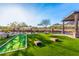 Community lawn with bocce ball, cornhole, seating, landscaping, and mountain views at 26853 N 89Th Dr, Peoria, AZ 85383