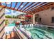 Backyard spa beneath a pergola, next to a pool with ample seating areas for entertaining at 26853 N 89Th Dr, Peoria, AZ 85383