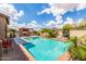 Sparkling backyard pool with inviting lounge area, built-in BBQ, and swaying palm trees at 26853 N 89Th Dr, Peoria, AZ 85383