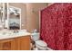 Cozy bathroom featuring a single sink vanity, red patterned shower curtain, and tiled flooring at 26853 N 89Th Dr, Peoria, AZ 85383