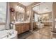 Elegant bathroom showcasing a large soaking tub, double sink vanities, mirrors and tiled floors at 26853 N 89Th Dr, Peoria, AZ 85383