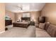 Spacious bedroom with a large bed, a ceiling fan, dresser, and a comfortable seating area at 26853 N 89Th Dr, Peoria, AZ 85383