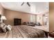 Bright bedroom featuring large bed, couch, dresser, ceiling fan, and lots of light at 26853 N 89Th Dr, Peoria, AZ 85383