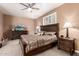 Comfortable bedroom featuring a ceiling fan, large bed with decorative pillows, side tables, and closet at 26853 N 89Th Dr, Peoria, AZ 85383