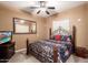 Comfortable bedroom with stylish metal bed frame, ceiling fan, television, and warm neutral wall color at 26853 N 89Th Dr, Peoria, AZ 85383