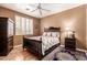 Lovely bedroom with hardwood floors, shuttered window, dark wood furnishings, and a ceiling fan at 26853 N 89Th Dr, Peoria, AZ 85383