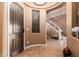 Welcoming home foyer with a staircase, decorative window, dark wood door, and neutral tile flooring at 26853 N 89Th Dr, Peoria, AZ 85383