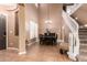 Home foyer boasts an elegant staircase, high ceilings, and tile flooring, leading to dining area at 26853 N 89Th Dr, Peoria, AZ 85383