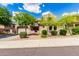 Charming desert home featuring a landscaped yard, attached garage, and a welcoming entrance with a wrought-iron gate at 26853 N 89Th Dr, Peoria, AZ 85383