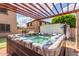 Hot tub nestled beneath a pergola offers a relaxing backyard experience with privacy at 26853 N 89Th Dr, Peoria, AZ 85383