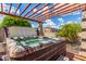 Luxurious backyard hot tub beneath a stylish pergola for relaxation and enjoying outdoor living at 26853 N 89Th Dr, Peoria, AZ 85383
