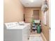 Well-lit laundry room featuring a washer and dryer and storage shelves at 26853 N 89Th Dr, Peoria, AZ 85383