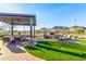 Community outdoor lounge with a fire pit, seating, turf lawn, and mountain views at 26853 N 89Th Dr, Peoria, AZ 85383