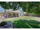 Lush backyard featuring a covered patio, manicured lawn, mature trees, and a serene outdoor space at 287 W Liberty Ln, Gilbert, AZ 85233