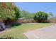 Expansive backyard featuring lush green grass, patio, landscaping, and a view of the beautiful blue sky at 287 W Liberty Ln, Gilbert, AZ 85233