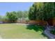 Beautiful backyard featuring lush green grass, mature shade trees, and ample space for recreation and relaxation at 287 W Liberty Ln, Gilbert, AZ 85233