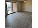 Open living room with new floors, and sliding glass doors leading to the balcony at 3810 N Maryvale Pkwy # 2061, Phoenix, AZ 85031