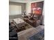 Comfortable living room with leather reclining sofa, decorative rug, light-colored wood flooring, and modern art at 4065 E University Dr # 242, Mesa, AZ 85205