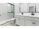 Modern bathroom boasts double sinks, sleek white cabinetry, and a glass-enclosed shower at 42460 W Peters Dr, Maricopa, AZ 85138