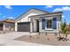 Lovely single-story home featuring a gray garage door and a pop of color from the blue shutters at 42460 W Peters Dr, Maricopa, AZ 85138