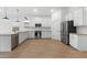 Modern kitchen featuring stainless steel appliances, white cabinets, and wood-look tile floors at 42460 W Peters Dr, Maricopa, AZ 85138