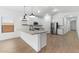 Bright kitchen features an island, white cabinets, stainless steel appliances, and hardwood floors at 42460 W Peters Dr, Maricopa, AZ 85138
