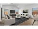 Cozy living room showcasing contemporary decor, a stylish rug, and a large screen TV at 42460 W Peters Dr, Maricopa, AZ 85138