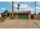 Exterior view of a single-story home featuring a two car garage, lush front lawn, and mature palm trees at 4530 W Larkspur Dr, Glendale, AZ 85304
