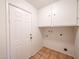 Laundry room with tile floors, access to the exterior, and upper cabinets at 4530 W Larkspur Dr, Glendale, AZ 85304