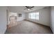 Bright living room featuring plush carpet, a ceiling fan, neutral walls, and tile entryway with kitchen view at 4530 W Larkspur Dr, Glendale, AZ 85304