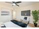 Bedroom includes a modern ceiling fan, TV, bench, and view through large windows to the home exterior at 4538 E Shomi St, Phoenix, AZ 85044