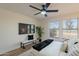 Stylish bedroom includes a modern ceiling fan, TV, bench, and view through large windows to the home exterior at 4538 E Shomi St, Phoenix, AZ 85044