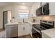 Kitchen with stainless appliances, tiled backsplash, quartz countertops and view to the outside at 4538 E Shomi St, Phoenix, AZ 85044