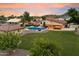 Aerial view showcasing the pool, large landscaped yard, outdoor kitchen, and mature trees at 5044 W Electra Ln, Glendale, AZ 85310
