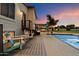 Inviting backyard with a wooden deck, comfortable lounge chairs, an outdoor kitchen, and a refreshing swimming pool at 5044 W Electra Ln, Glendale, AZ 85310