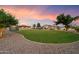 Large grassy backyard featuring a pool, lounge area, mature trees, and a well-maintained lawn at 5044 W Electra Ln, Glendale, AZ 85310