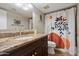 Bathroom with a dark wood vanity, granite countertop, and a shower with a modern shower curtain at 5044 W Electra Ln, Glendale, AZ 85310